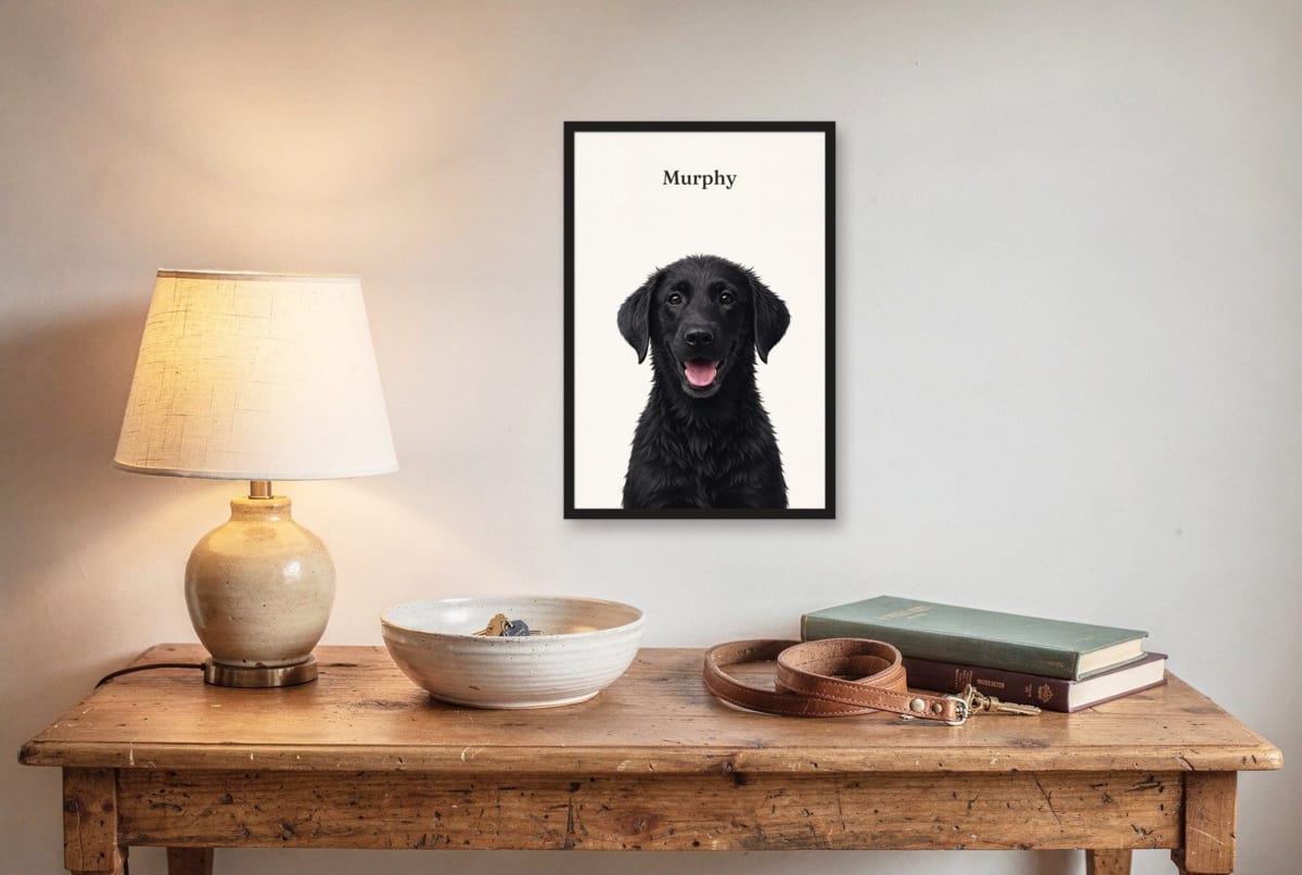 Illustration of a framed portrait of a black Labrador puppy, 12x18 inches in a black frame, hanging above a table with a lamp, with the name Murphy above the head
